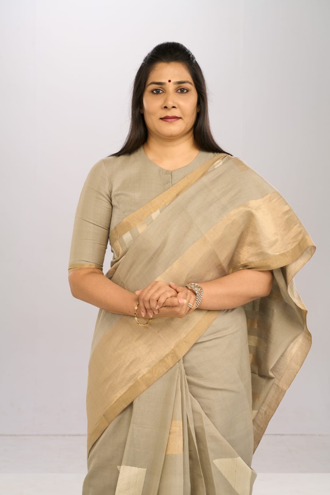 Formal portrait in a beige saree.