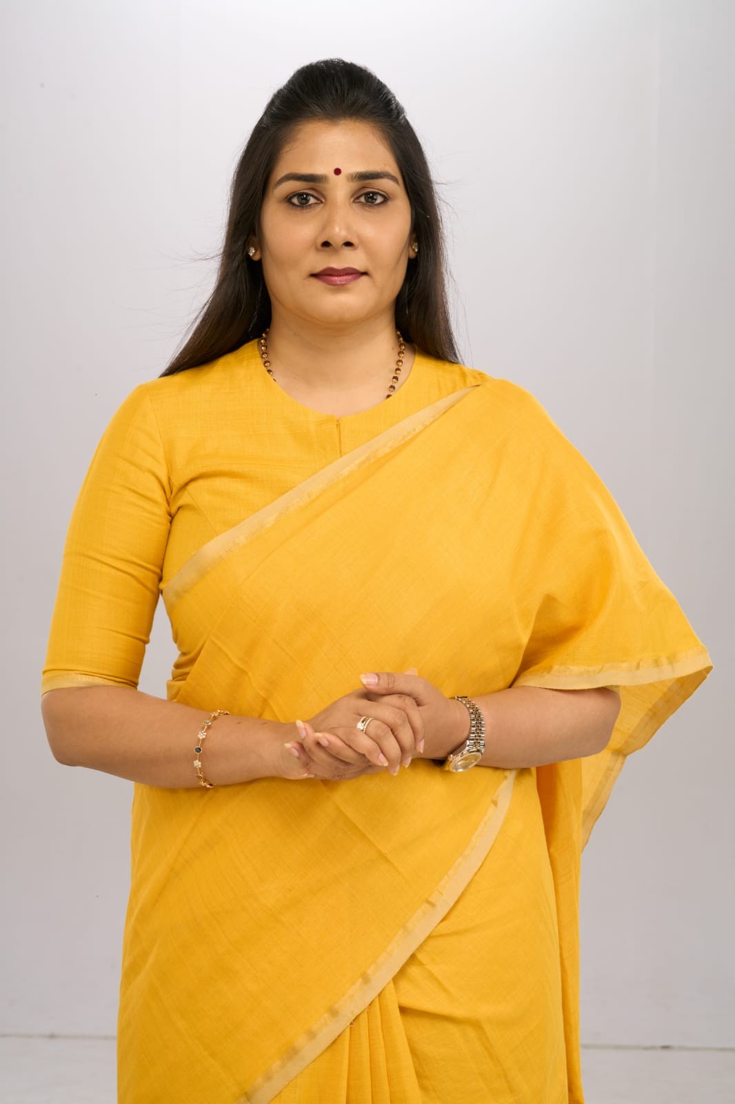 Formal portrait in a yellow saree.
